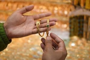 एक हाथ पर एक लग्जरी सोने का ब्रेसलेट आज़माते हुए